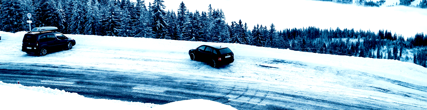 two cars on an icy, snowy road spinning out