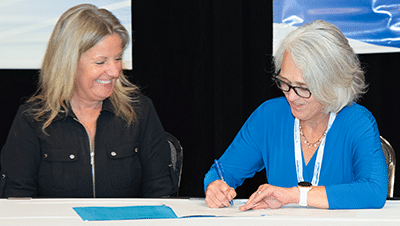 Janie and OSHA representative signing Alliance agreement
