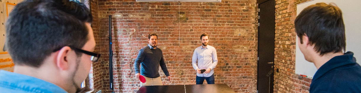 image of 4 men playing ping pong at work