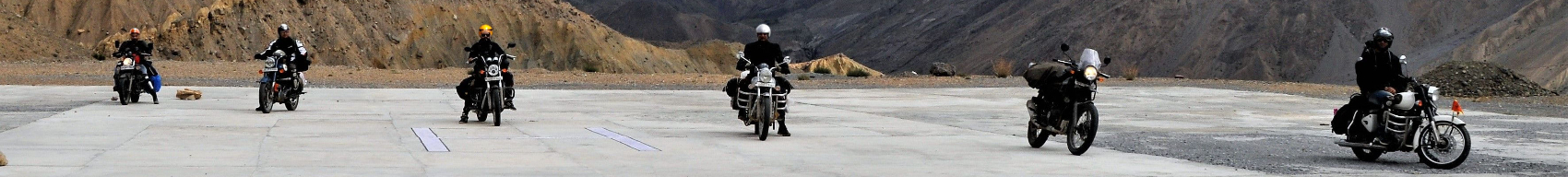 6 motorcycles spaced out across a road
