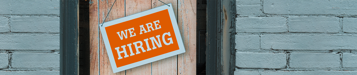image of a Now Hiring Sign on a wood door