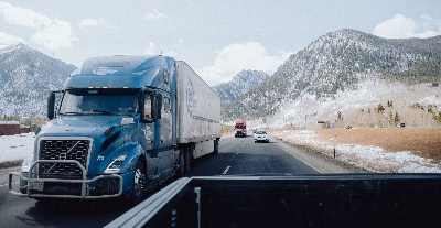 truck driving on a highway through the mountains in the fog with other traffic